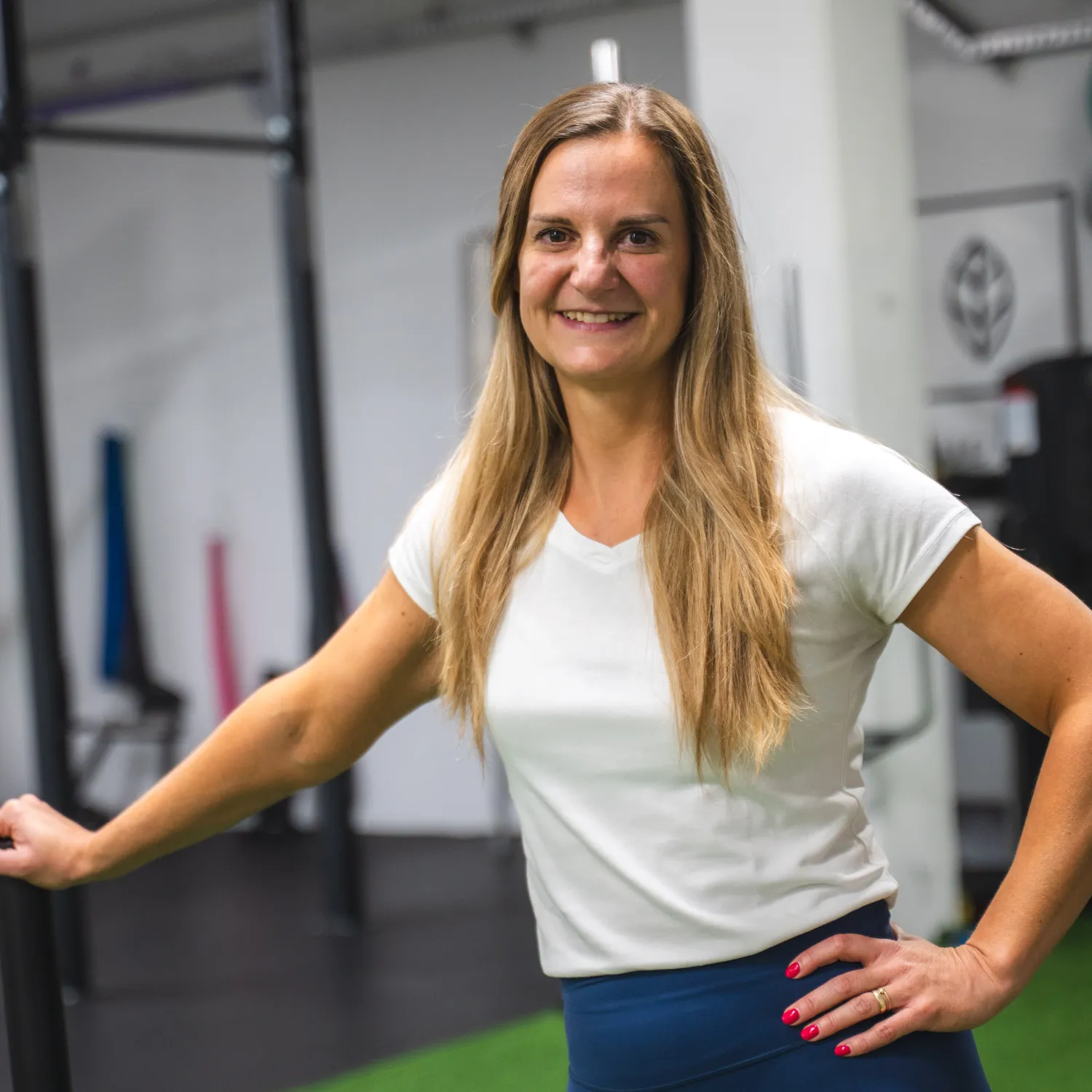 Osebna trenerka Darija Cvetko v fitnesu – nasmejana ob vadbeni opremi, pripravljena na individualno svetovanje in osebne treninge.